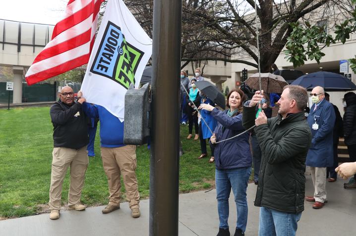 Image of raising white donate life flag