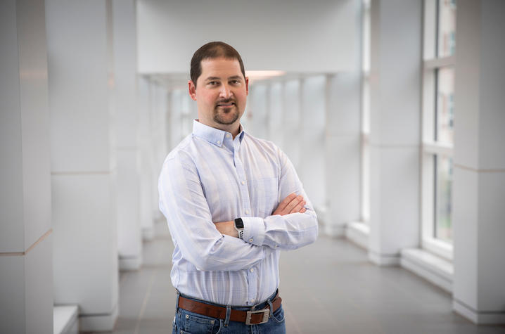 Photo of Andy Wilkins standing in glass and white corridor 