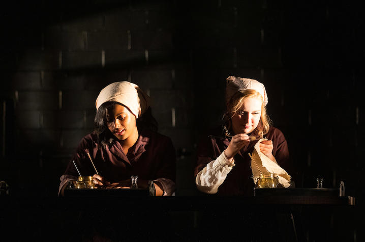 photo of 2 cast members working in UK Theatre's "Radium Girls"