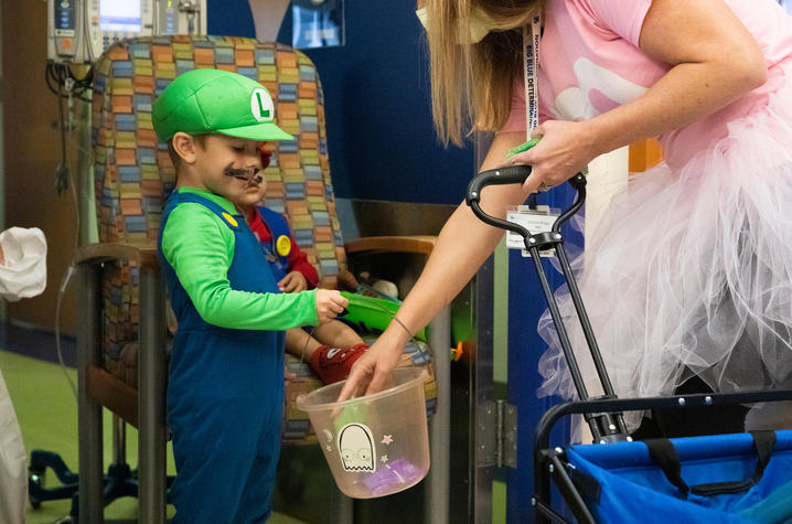 image of a child dressed like Luigi getting candy at KCH