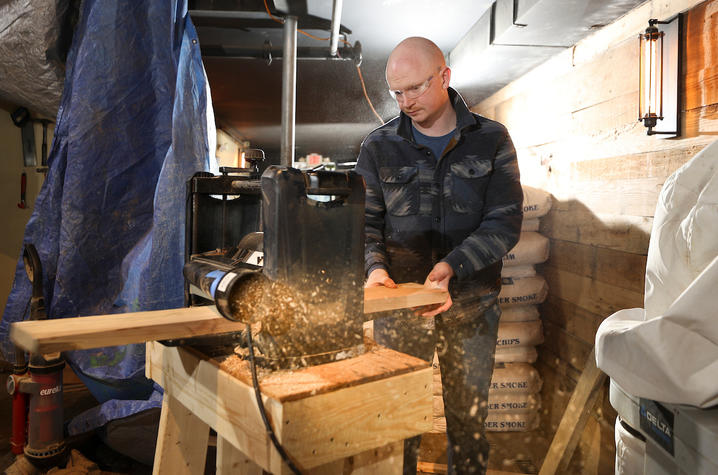 Image of Jacob running a piece of wood through a machine