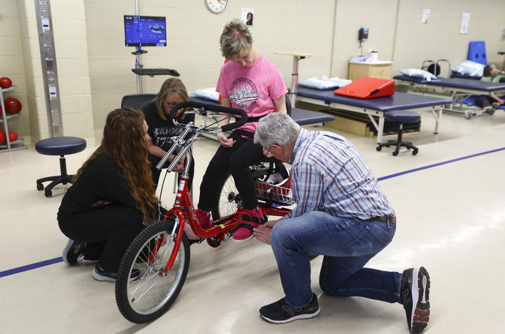 The AMBUCS team makes sure the bike fits Standiford perfectly. Carter Skaggs | UK photo