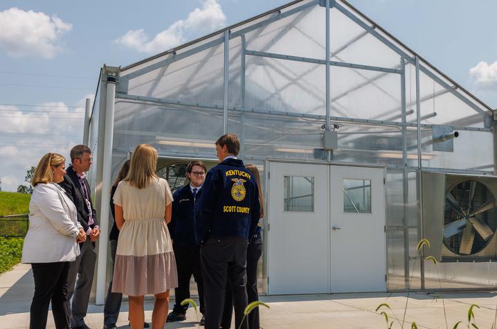 Students standing in front of a greenhouse