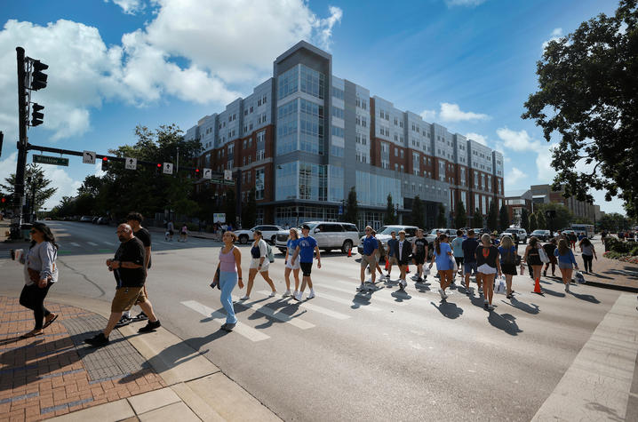 students walking across a crosswalk on campus