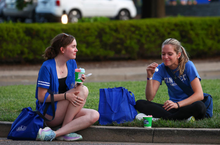 Students sitting eating snow cones. 