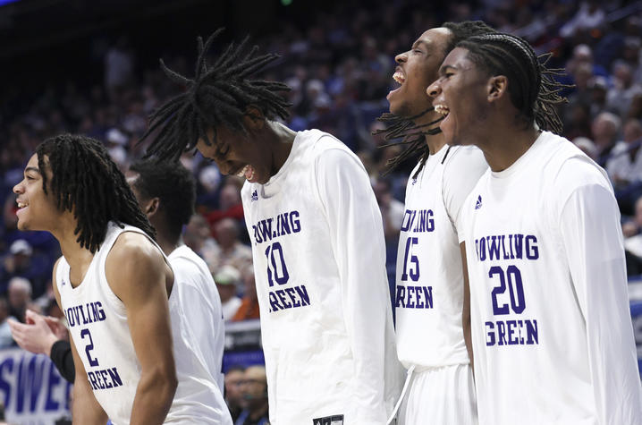 High school basketball players showing excitement on the sidelines. 