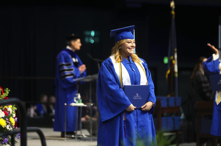 Marilyn Simpson standing with her diploma at Commencement. 