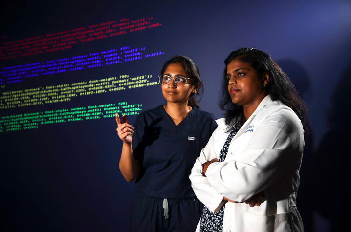 Two women pointing at digital text