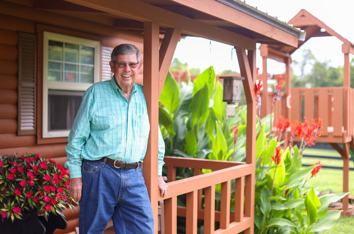 Bily Fryer poses on the porch of a cabin