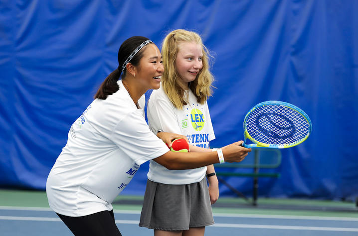 Image of a little girl learning how to play tennis