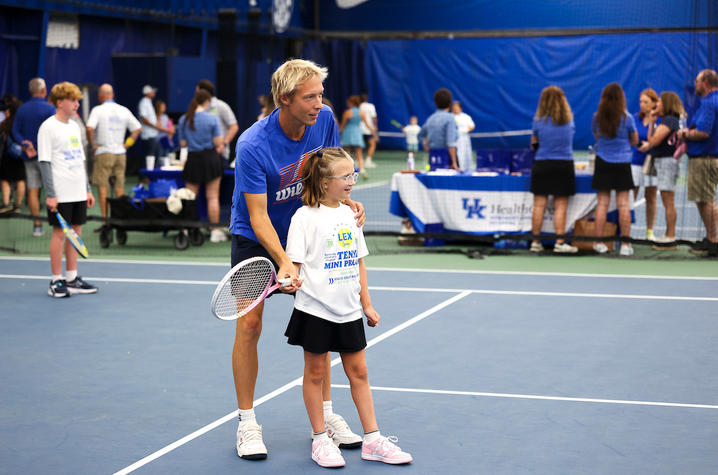 Image of a little girl being coached in tennis
