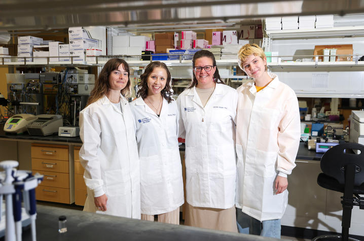Caroline Geisler (center with glasses) stands in her lab at UK with three of the members of her lab team