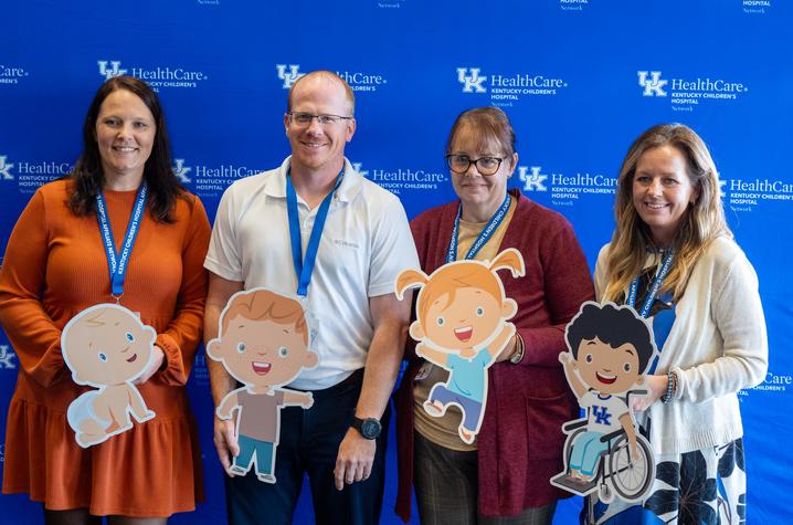 Image of four people in front of a blue background