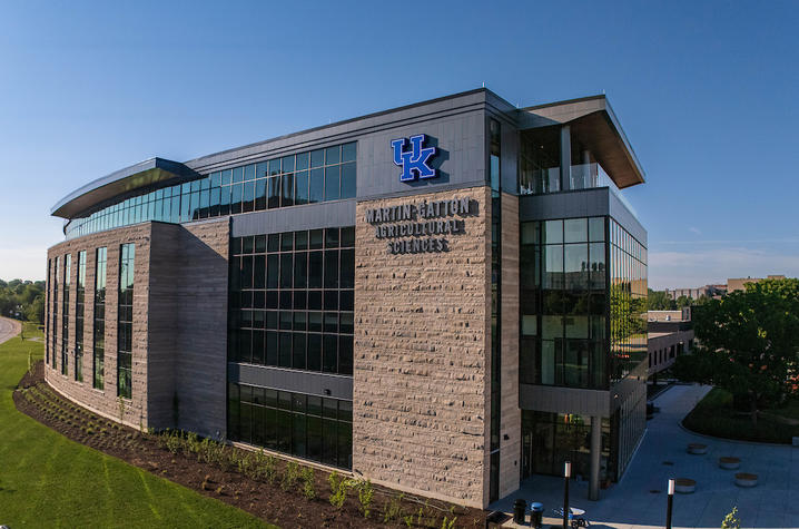 photo of UK Ag Sciences Building Aerial view of the University of Kentucky’s Martin-Gatton Agricultural Sciences building, featuring a stone-and-glass exterior and a large UK logo under a clear blue sky.