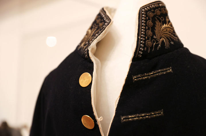 Historic military-style coat on exhibit display.