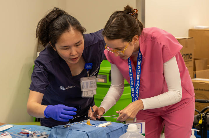 Photos of providers at the Golisano affiliate conference in training simulation Two conference attendees practice a clinical procedure on an infant training mannequin during a hands-on pediatric simulation session.