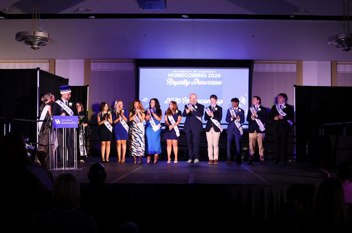 Homecoming court members stand together onstage during the Homecoming Royalty Showcase.