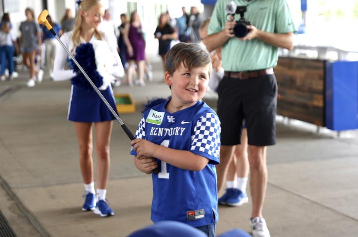 image of young boy in blue jersey with a mini golf club