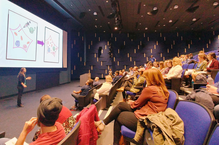photo of student researcher presenting to audience in Worsham Cinema