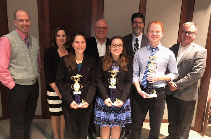 photo of three student winners with trophies and faculty and administrators at 5-Minute Fast Track Research Competition