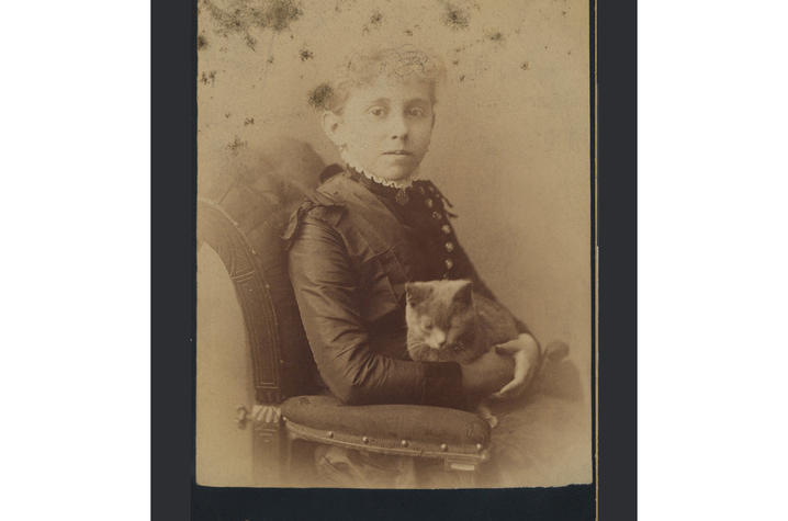 old sepia tone photo of girl seated with cat in her lap