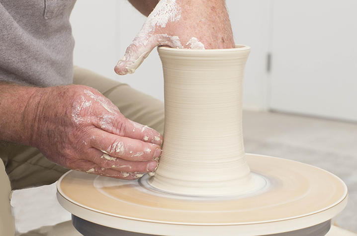 photo of hands working on ceramic vase