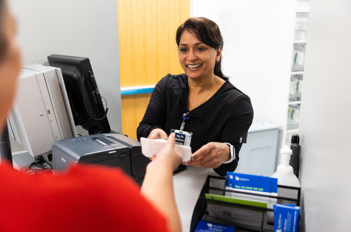 Pharmacist handing medications to customer