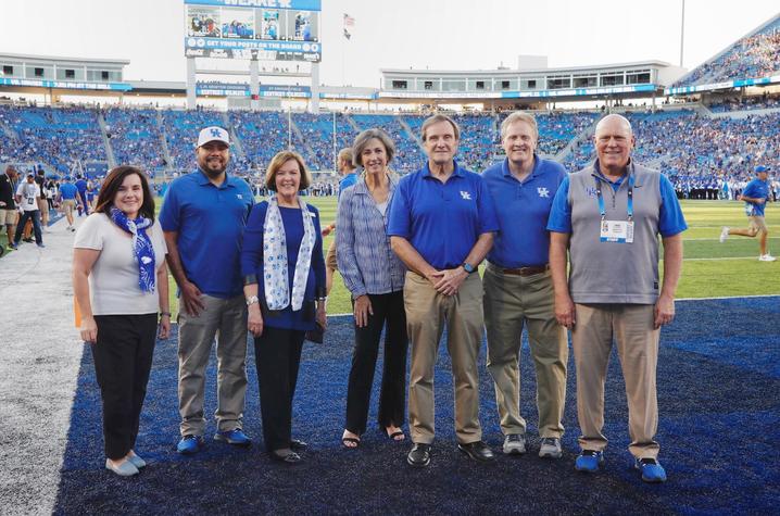 photo on Kroger Field of Jennifer Greer, Julian Vasquez Heilig, Rossetta Sandidge, Mary Davis, Jeffrey Okeson, Derek Lane, and Provost David Blackwell.  