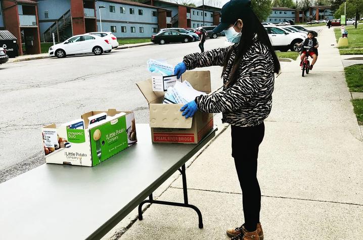 photo of Confucius Institute worker placing masks on table near graduate student housing