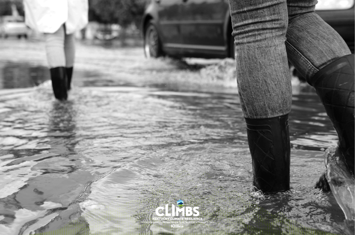 Two people wade through standing water after floods hit small communities