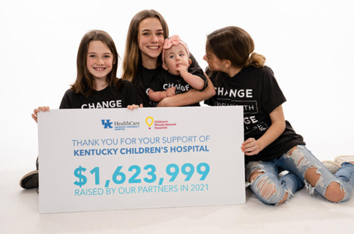 image of family with sign announcing $1,623,999 total from children's miracle network