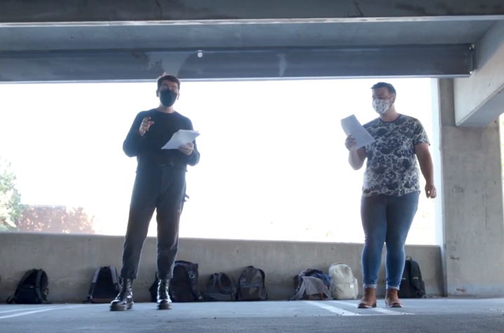 photo of 2 masked acoUstiKats rehearsing in garage structure with backpacks on ground behind them