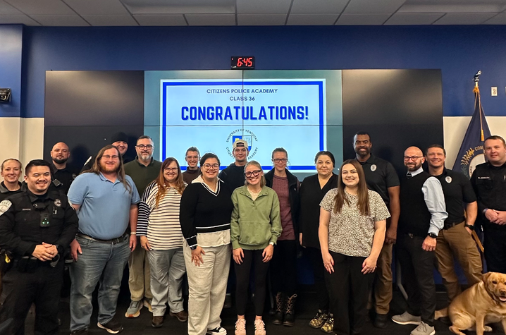 UK Police Department’s Citizen Police Academy a photo of the Citizen’s Police Academy gradation in the emergency operations center. The group is standing and smiling.