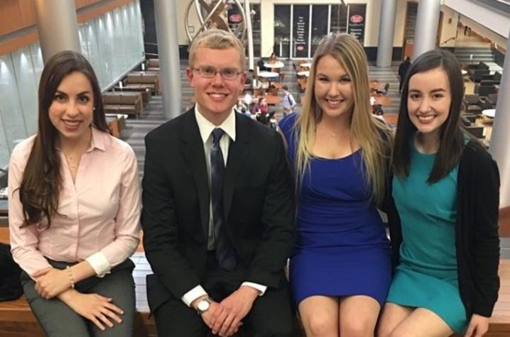 photo of Natalya Hippisley, Brennan Dodds, Haley Holthaus, Amy Keith - CatSwap Books in the Gatton Building with hanging sculpture, dining area behind them