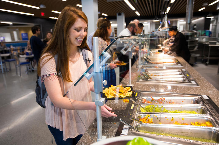 photo of young woman at a food buffet