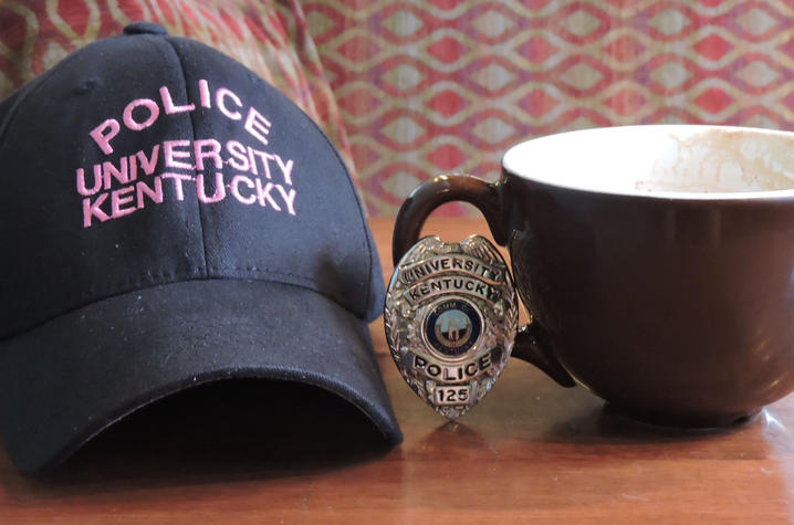 photo of hat that says UK Police, a UK Police badge and a coffee cup