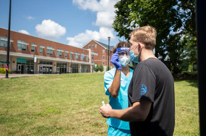 an employee of the COVID-19 testing company, Wild Health, swabs a student's nose during COVID-19 testing at the beginning of the semester.