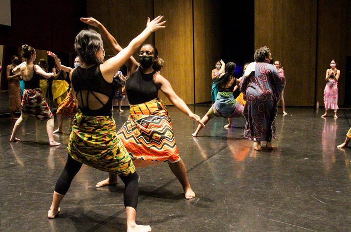 Dancers rehearsing on a black stage