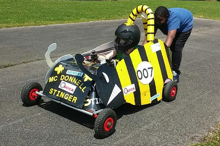 photo of two students working with an electric vehicle