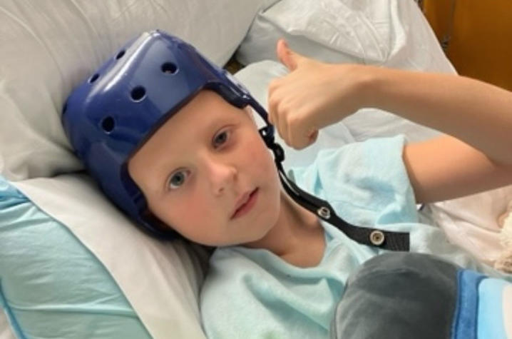 Image of William in hospital bed giving thumbs up