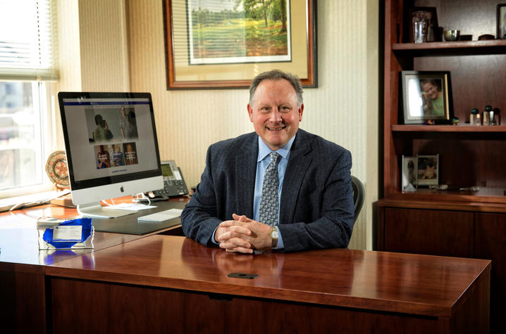 dean Lephart sitting and smiling at his desk