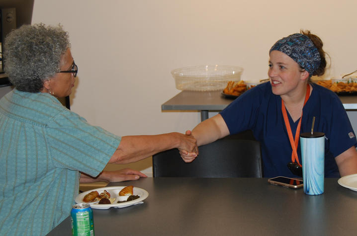Dr. Callie Dowdy, surgical resident, greets one of the artists at the ArtsCAFE open house.