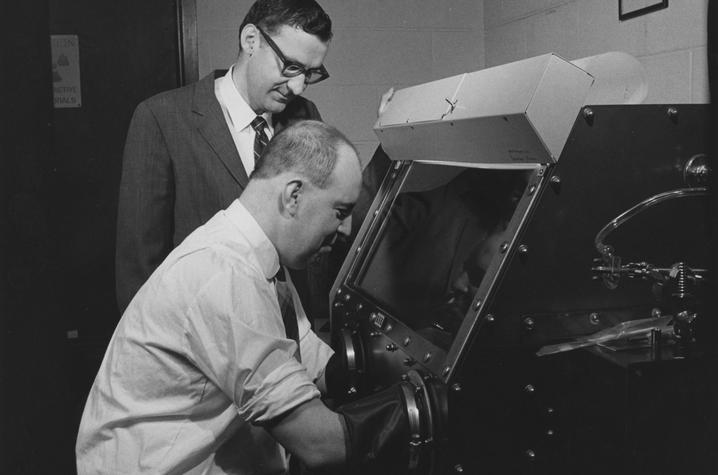 photo of Bill Ehmann and John Morgan studying moon rock
