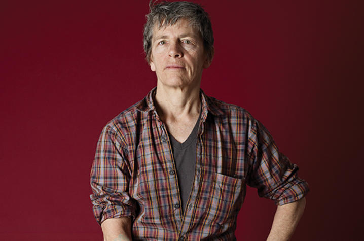photo of Eileen Myles on stool with red background by Catherine Opie