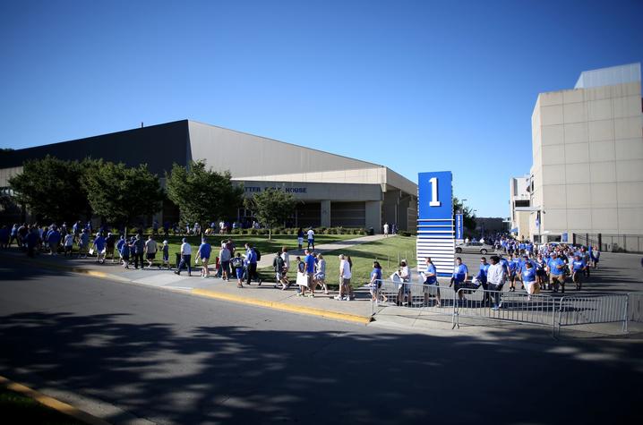 photo of exterior of Nutter Field House at Fan Day.  People are walking in a line to get into the facility to meet players.