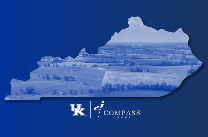 Blue graphic of the state of Kentucky filled with an aerial view of farmland and rolling hills. The University of Kentucky “UK” logo appears at the bottom left, paired with the Compass Group logo on a solid blue background.