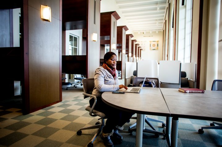 photo of graduate student working on laptop in William T. Young Library