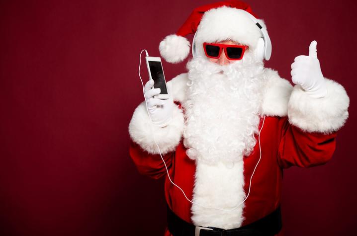 stock photo of Santa in sunglasses listening to an ipod giving a thumbs up
