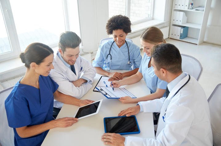 Medical residents at table. Group of happy doctors meeting at hospital office