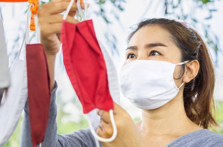 photo of woman hanging a face mask up to dry.